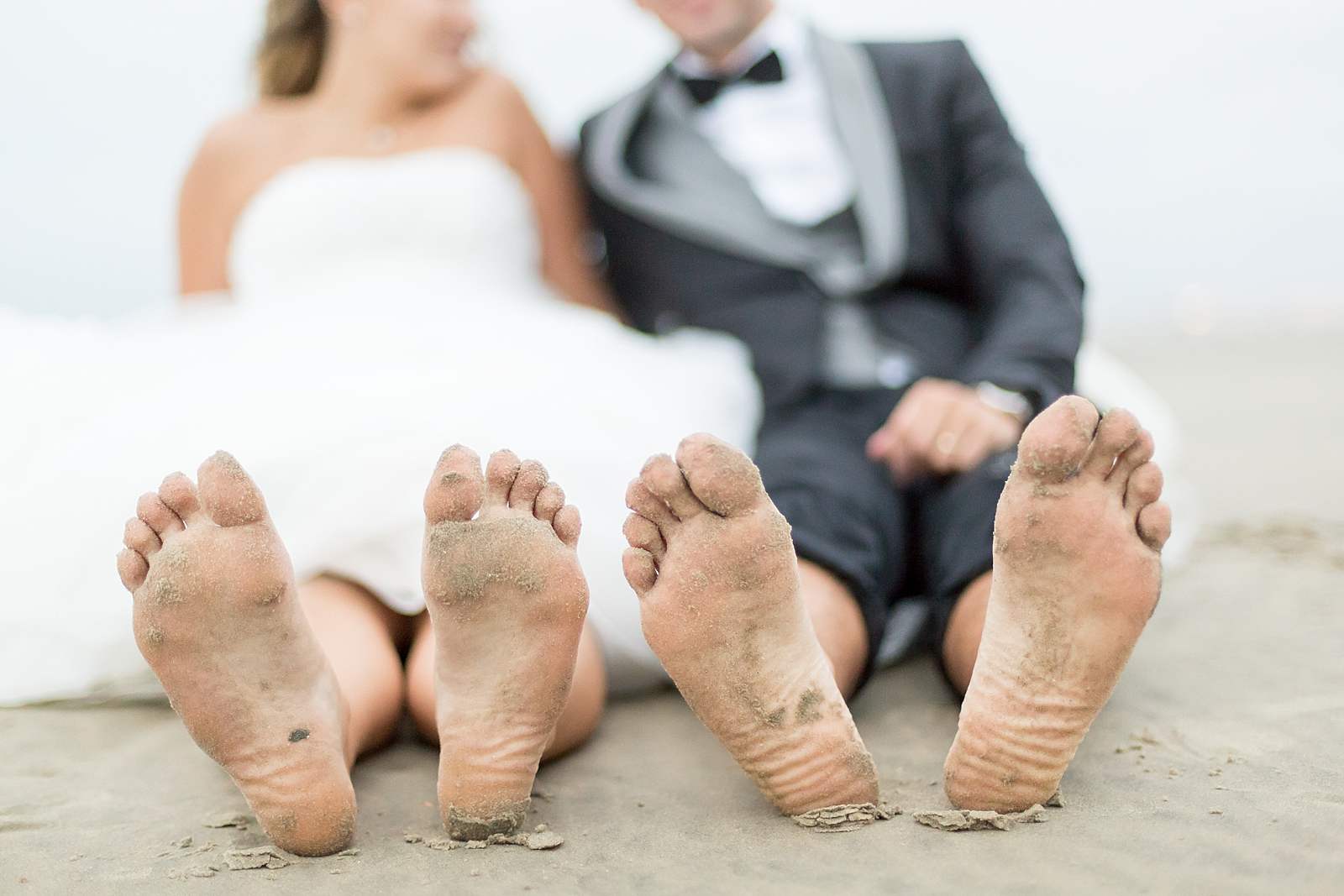 portrait des pieds des jeunes mariés pleins de sable.