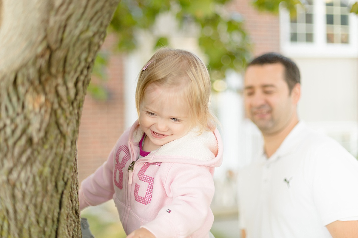 Papa et sa fille jouent à grimper aux arbres pendant la séance famille