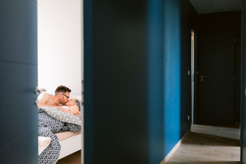 Photographie de couple intime dans leur chambre. Couloir bleu roi.