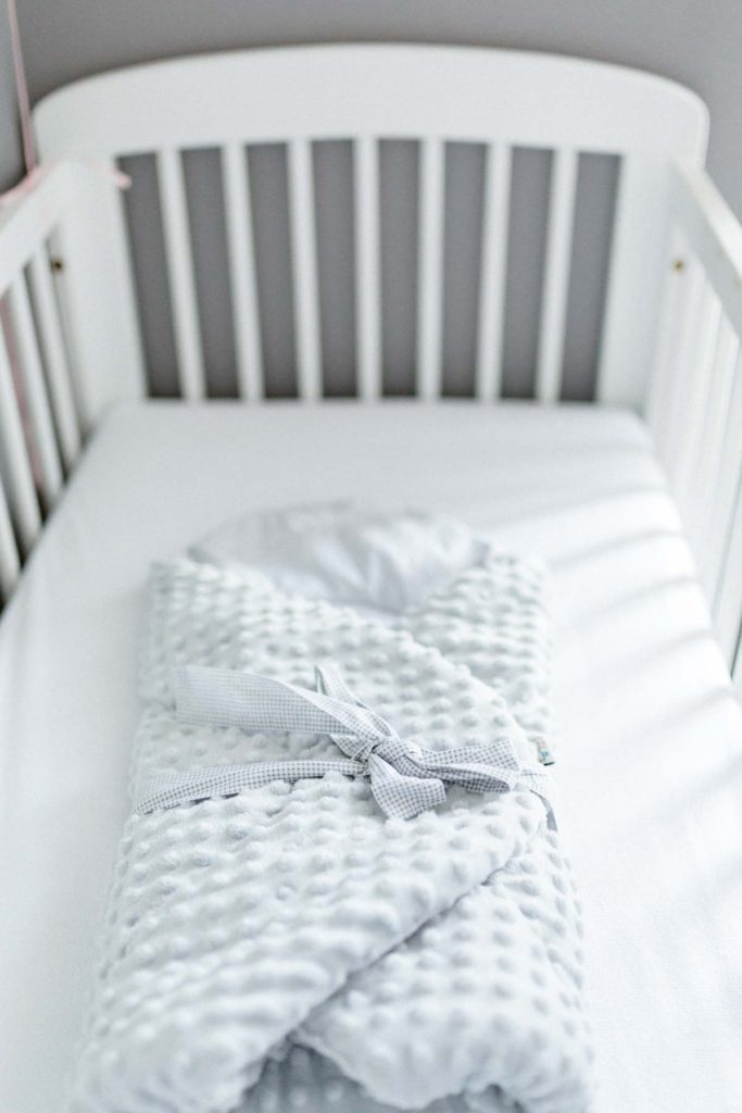 Lit de bébé blanc et couverture de lit. Le lit de bébé est prêt.